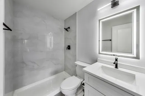 a white toilet sitting next to a bathroom sink