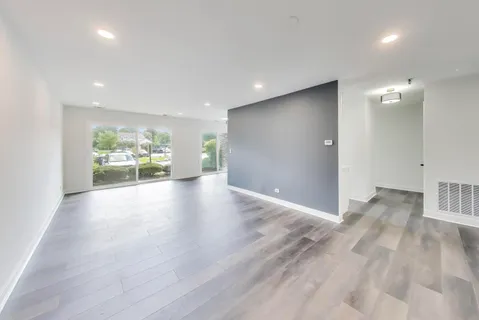 a view of an empty room with wooden floor