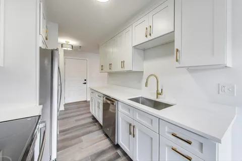 a kitchen with sink a refrigerator and cabinets