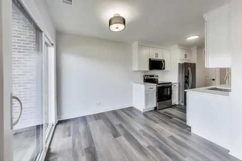 a kitchen with a refrigerator and a stove top oven