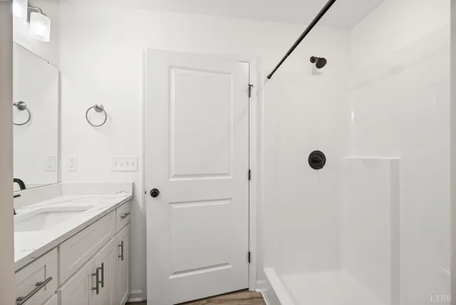 a bathroom with a shower sink and mirror