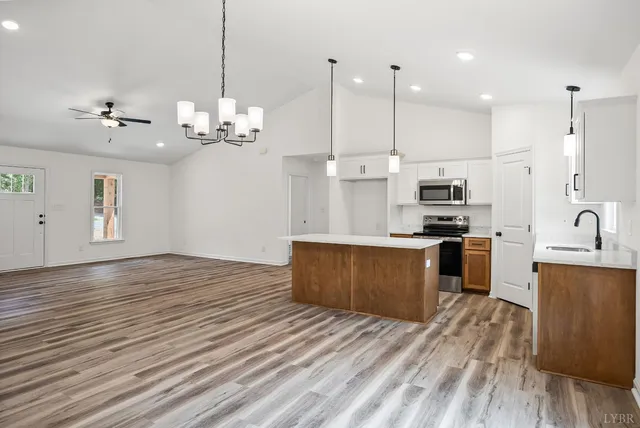 a large kitchen with kitchen island a sink stainless steel appliances and cabinets
