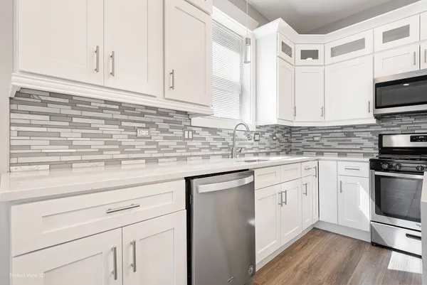 a kitchen with stainless steel appliances granite countertop a sink a stove and a microwave