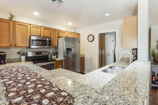 a kitchen with stainless steel appliances kitchen island granite countertop a refrigerator and a stove top oven