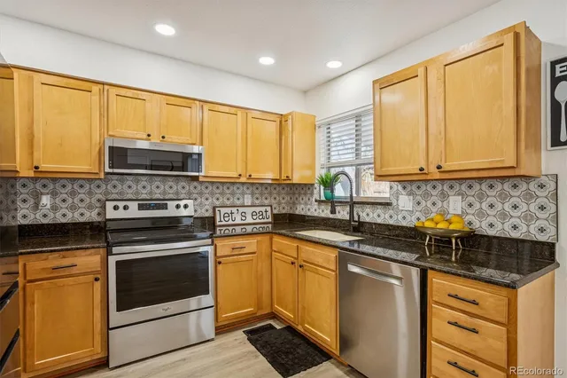 a kitchen with stainless steel appliances granite countertop a stove sink microwave and cabinets