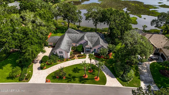 an aerial view of residential houses with outdoor space and trees
