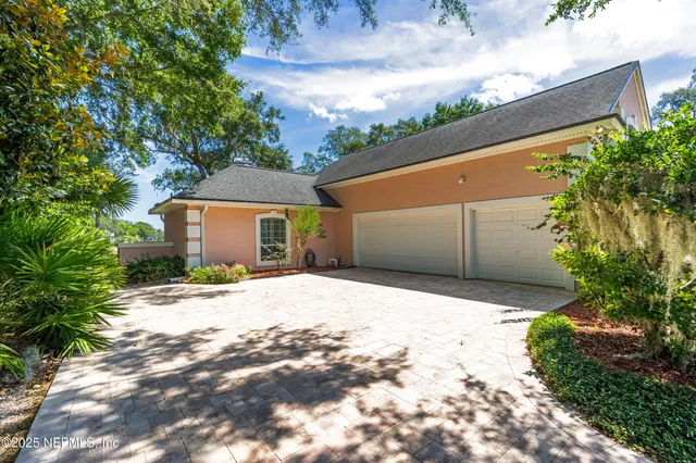 a view of a house with a big yard and large trees