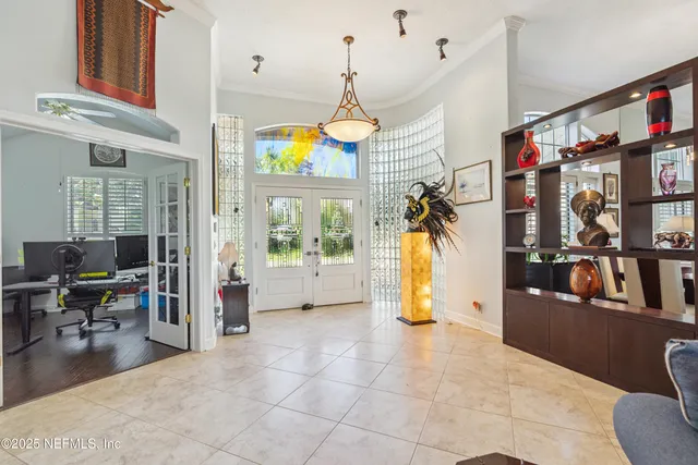 a living room with furniture a flat screen tv and a floor to ceiling window