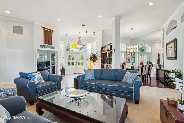 a view of a dining room with furniture a livingroom and chandelier