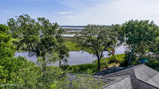 a street sign that is sitting in the grass near a building