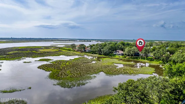 a view of a house with a big yard and palm trees