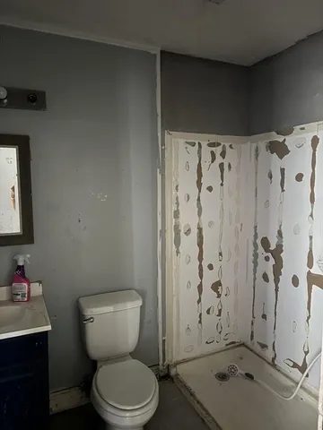 a bathroom with a toilet sink and shower