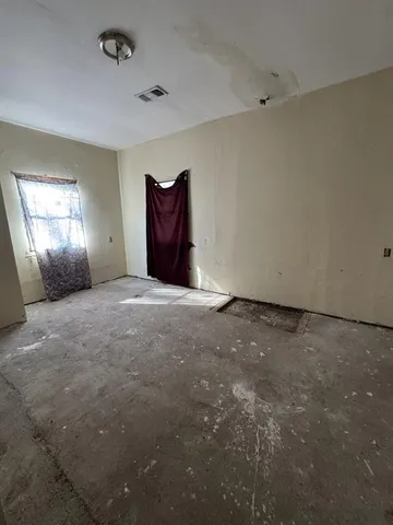 an empty room with windows and fireplace