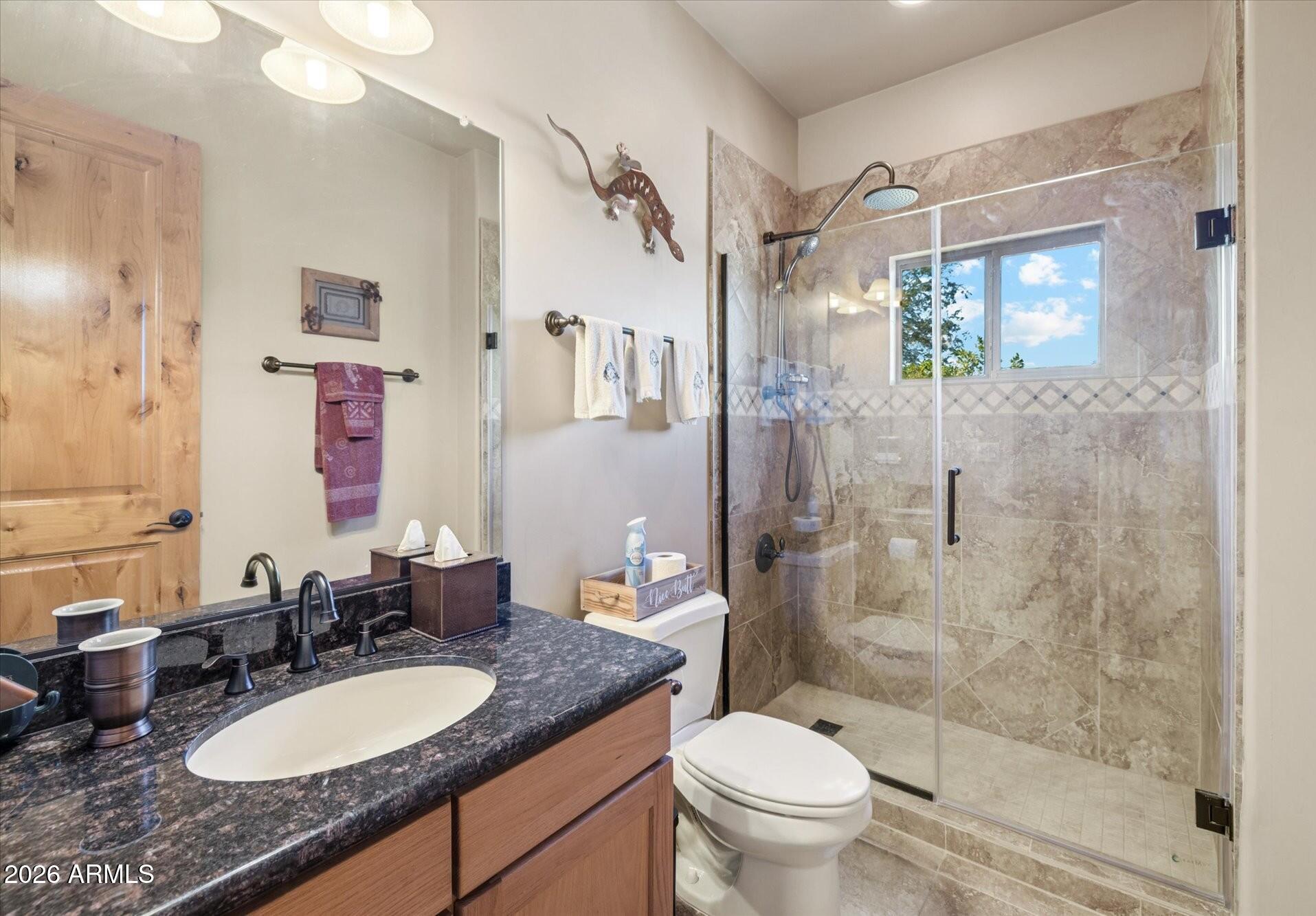 30012 North 170th Street Rio Verde, AZ 85263 - Photo 16 of 32 a bathroom with a granite countertop sink toilet a mirror a shower and a bathtub