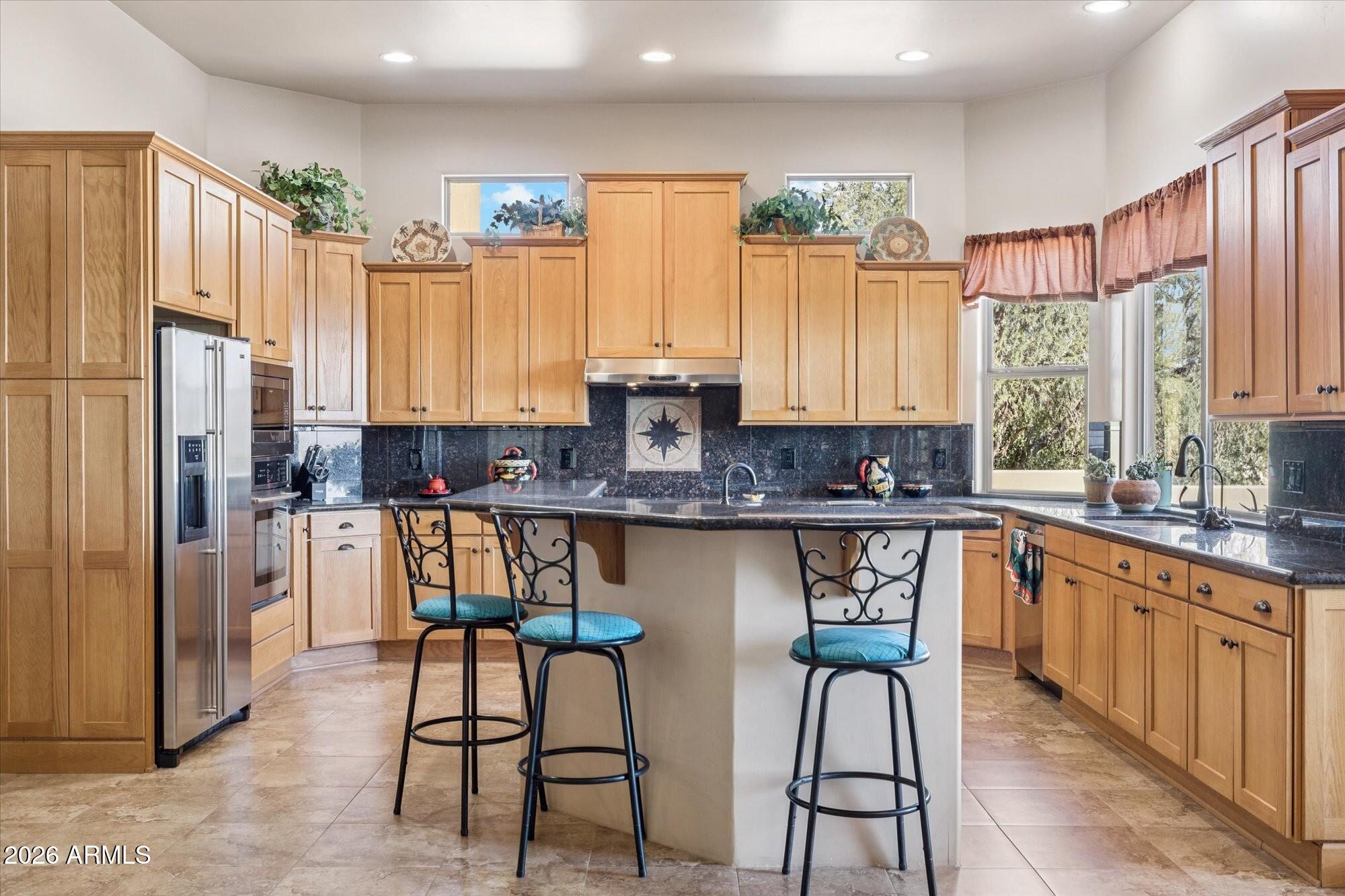 30012 North 170th Street Rio Verde, AZ 85263 - Photo 6 of 32 a kitchen with stainless steel appliances granite countertop a stove top oven a refrigerator a sink and white cabinets