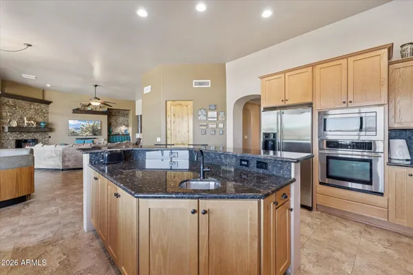a kitchen with stainless steel appliances granite countertop a sink a stove and a refrigerator