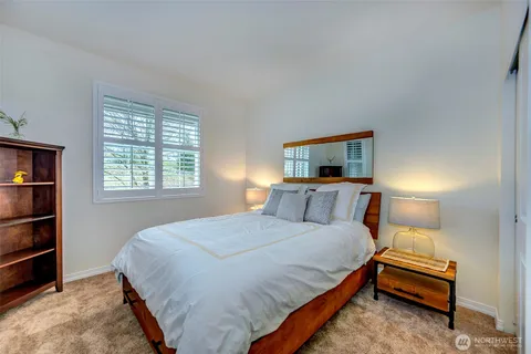 a bedroom with a bed a dresser and a window