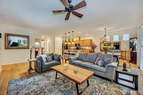 a living room with furniture kitchen view and a chandelier