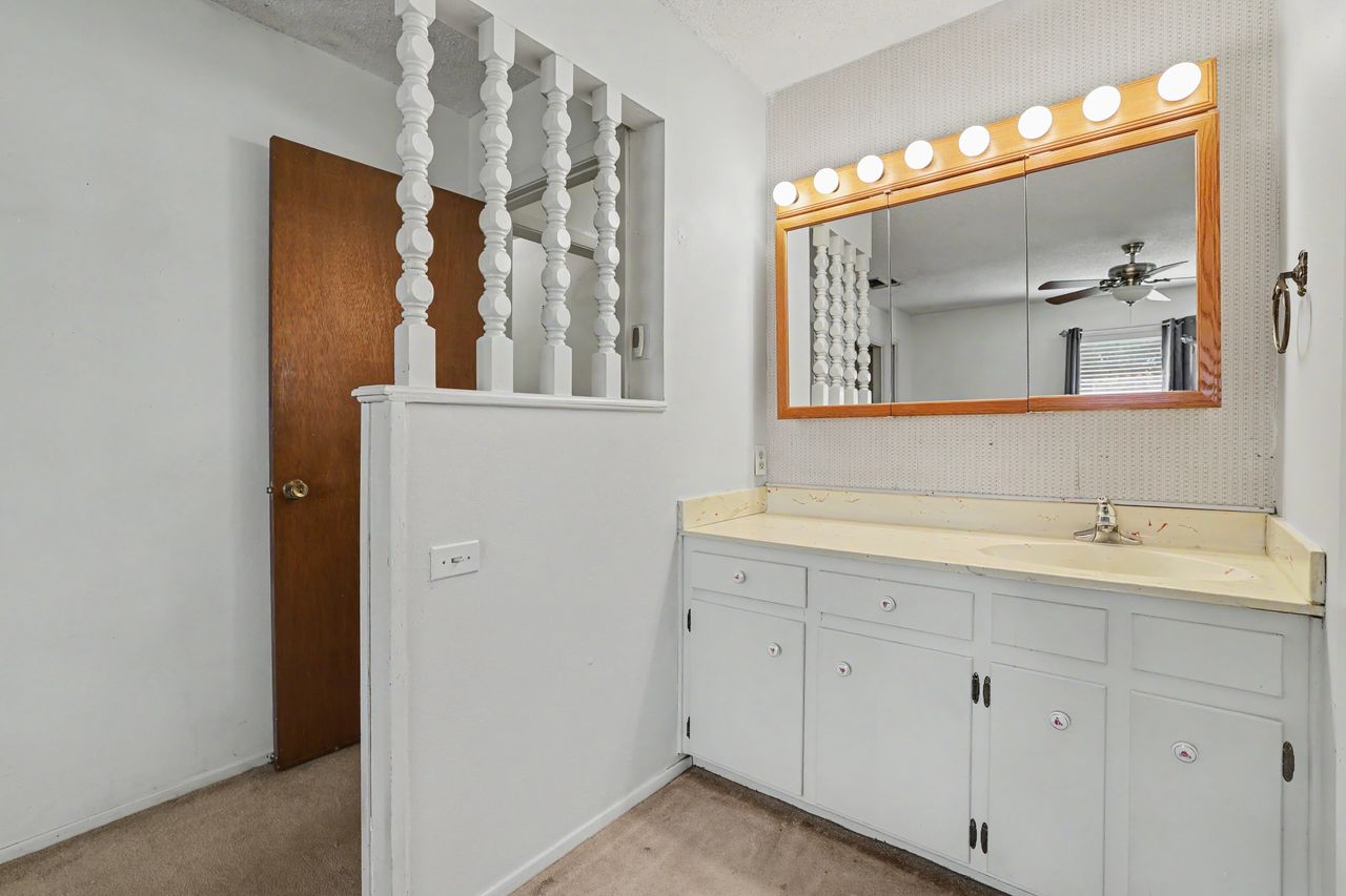 1811 Terry Lane Georgetown, TX 78628 - Photo 20 of 40 A classic vanity setup features ample counter space and storage beneath a large, illuminated mirror.