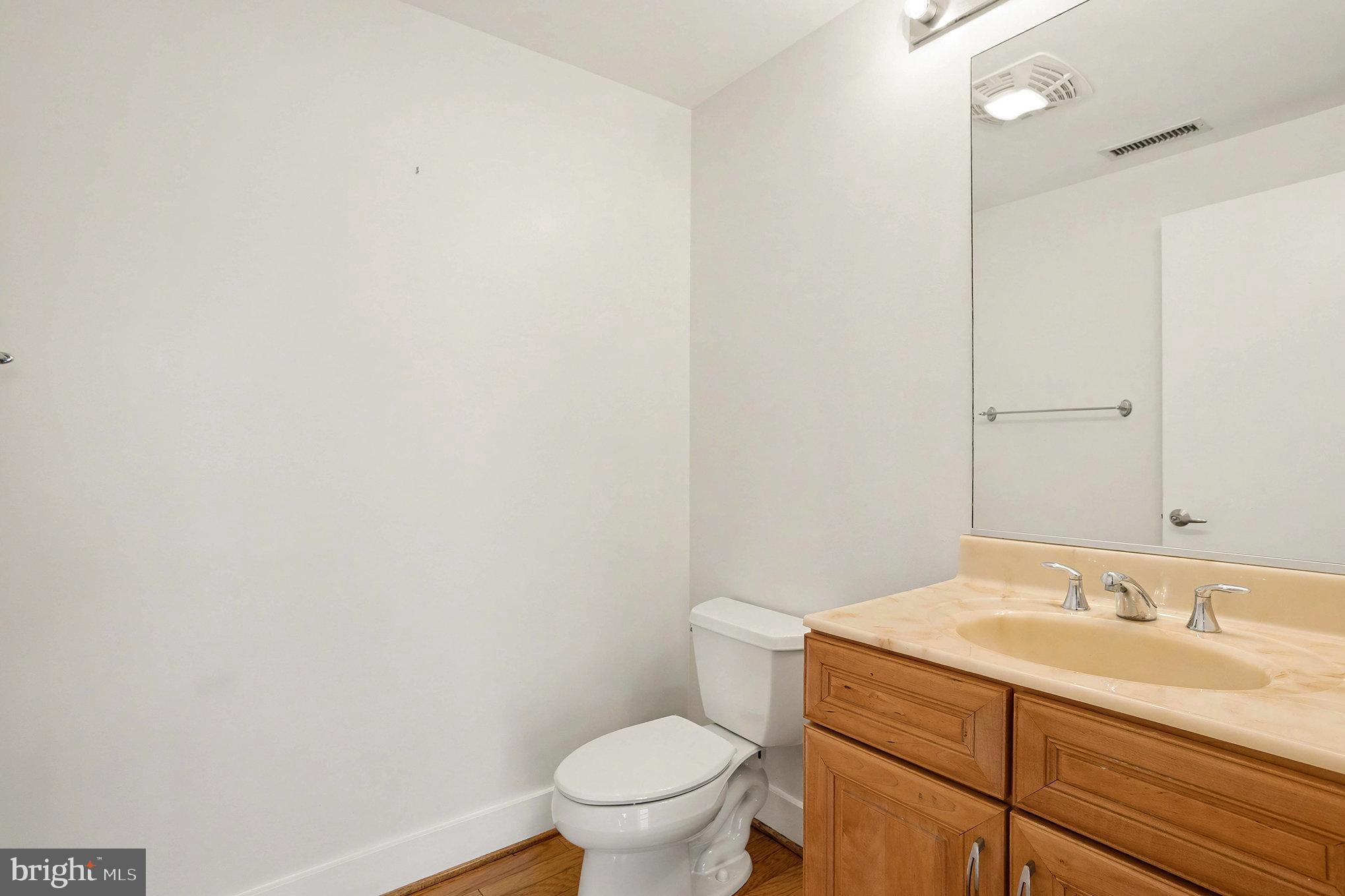 2772 Lighthouse Point East, Unit 201 Baltimore, MD 21224 - Photo 14 of 36 a bathroom with a sink a toilet and a mirror