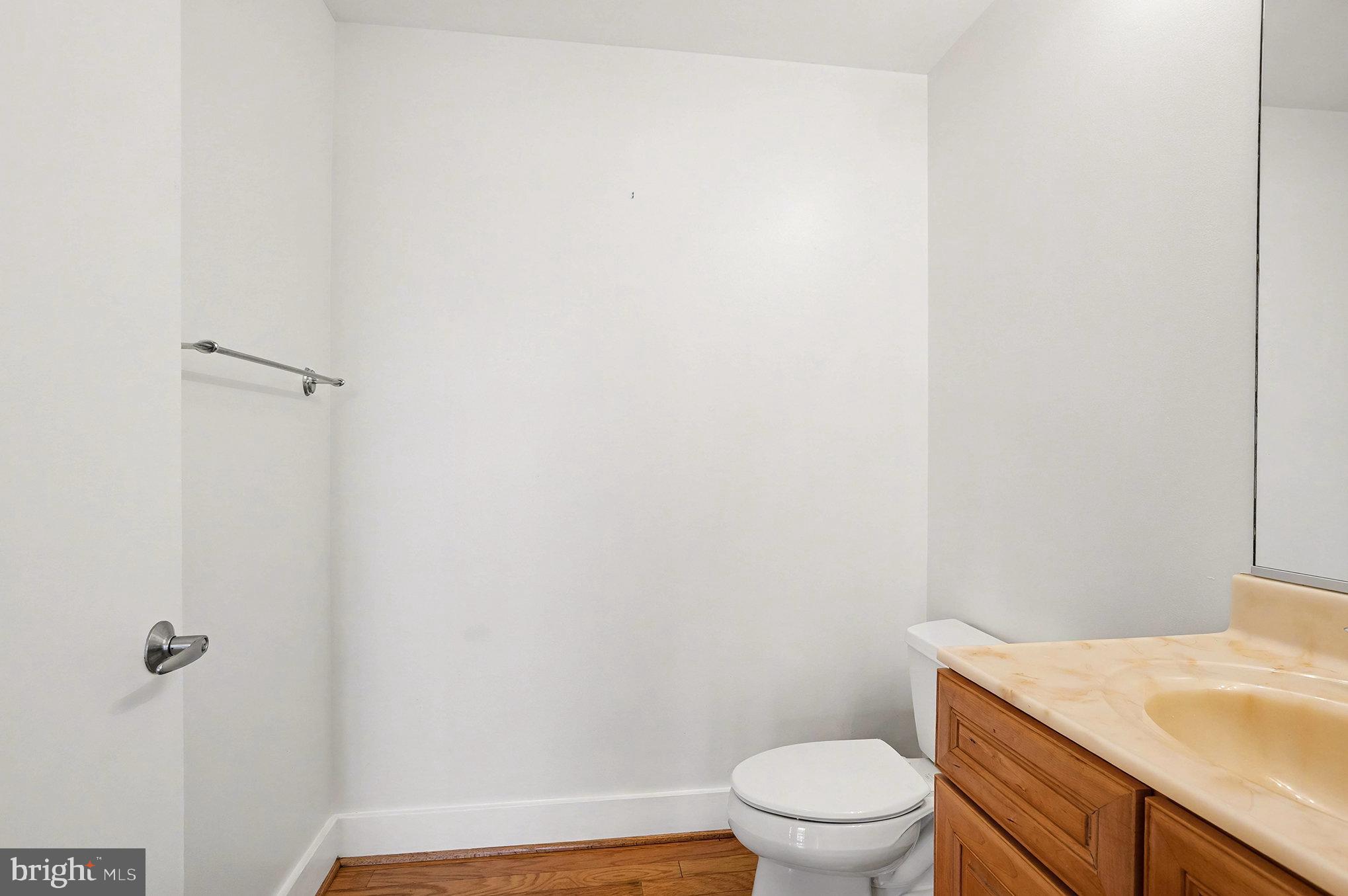 2772 Lighthouse Point East, Unit 201 Baltimore, MD 21224 - Photo 15 of 36 a bathroom with a granite countertop toilet and a sink
