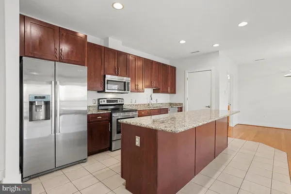 a kitchen with stainless steel appliances granite countertop a stove a refrigerator and a sink