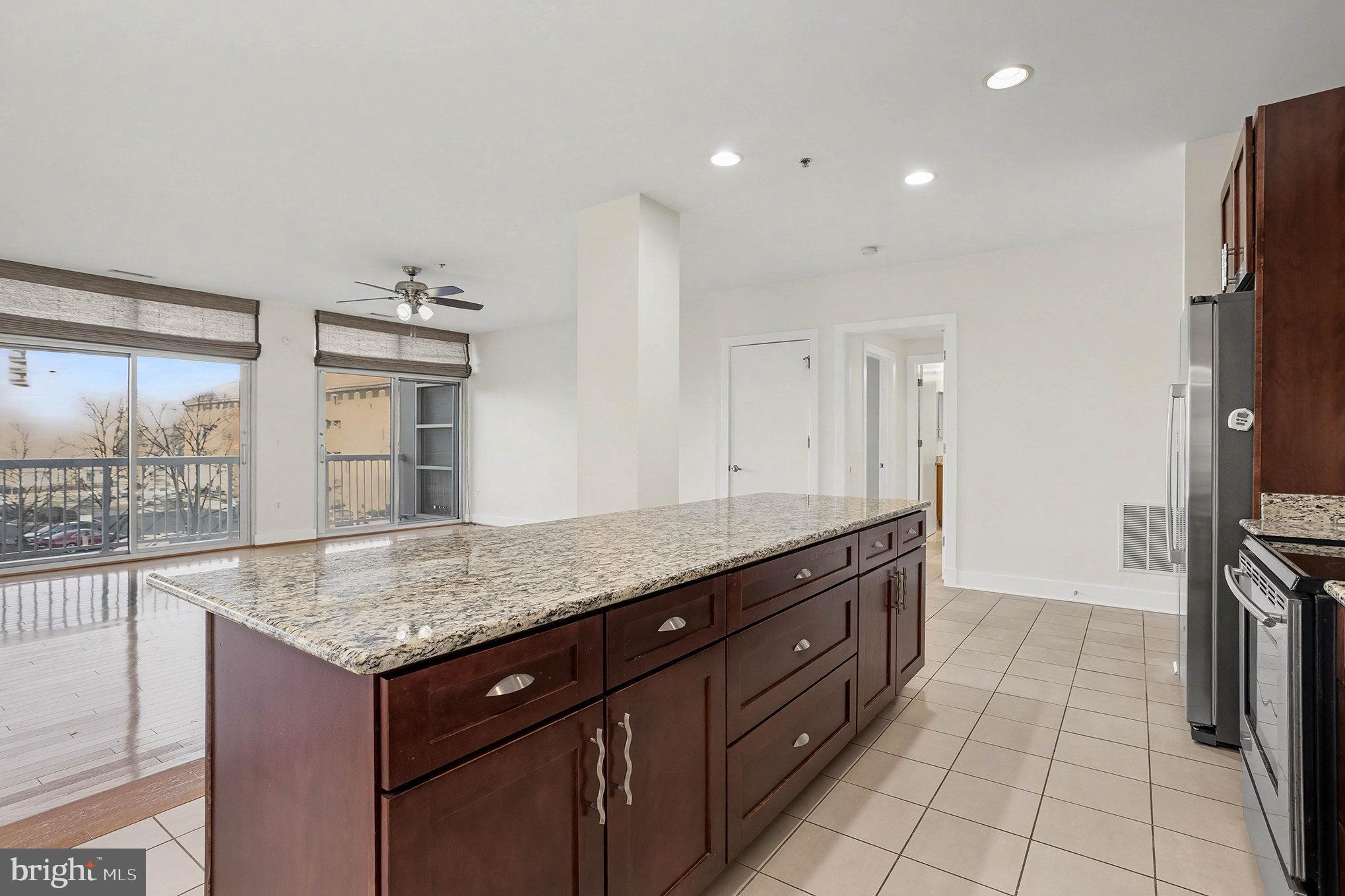 2772 Lighthouse Point East, Unit 201 Baltimore, MD 21224 - Photo 5 of 36 a bathroom with a granite countertop sink and a mirror