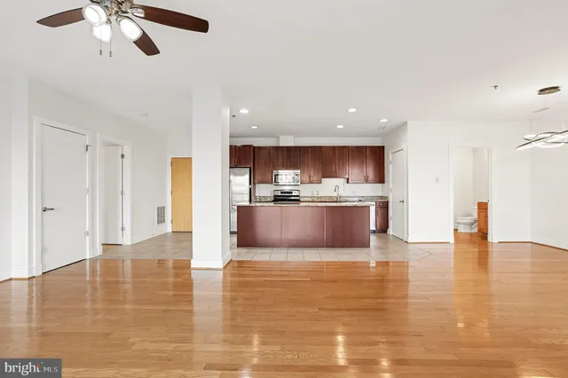 a large kitchen with stainless steel appliances granite countertop a large counter top and a chandelier