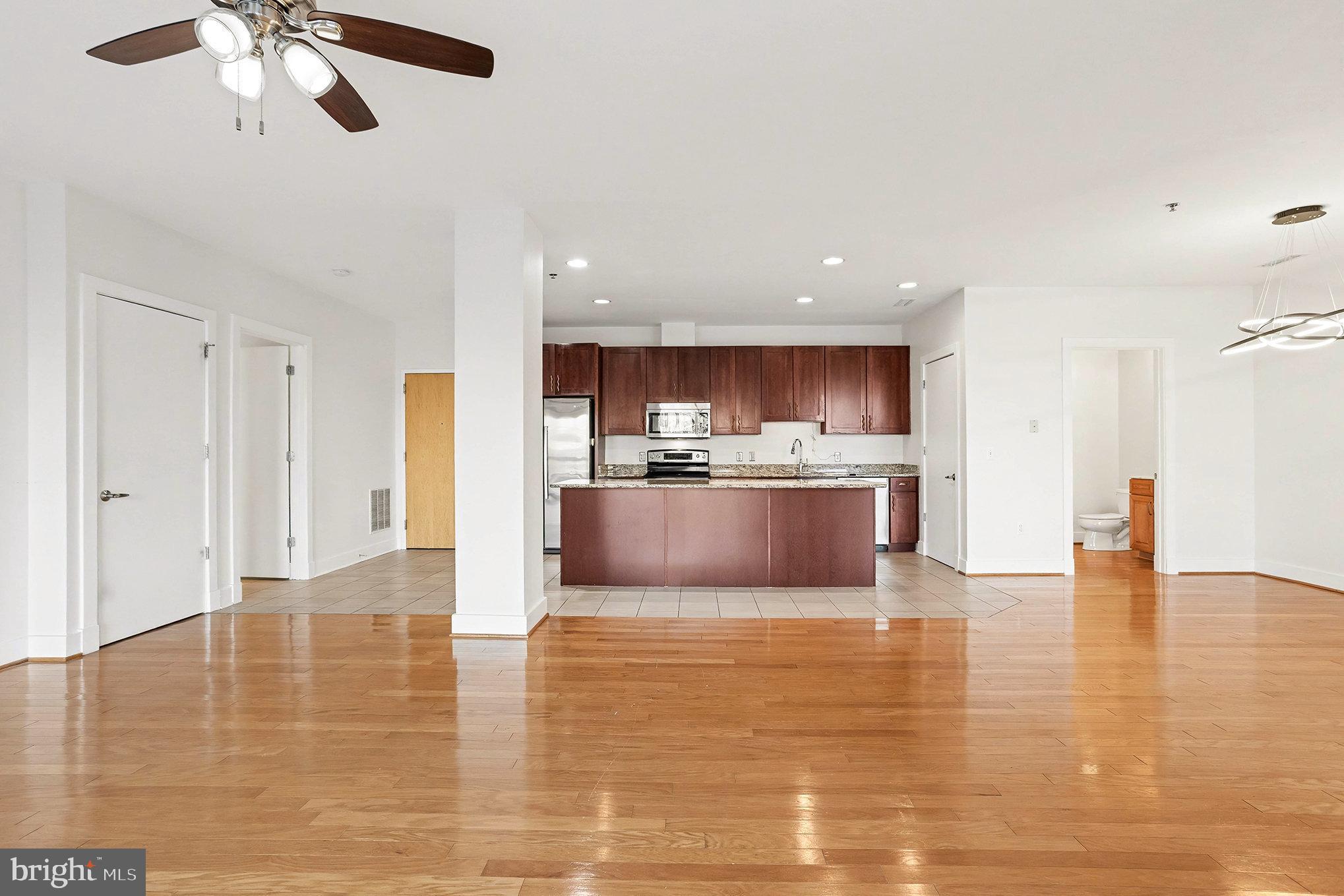 2772 Lighthouse Point East, Unit 201 Baltimore, MD 21224 - Photo 10 of 36 a large kitchen with stainless steel appliances granite countertop a large counter top and a chandelier