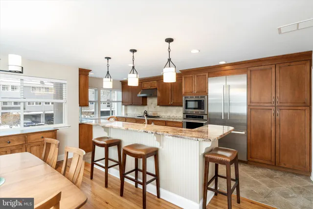 a kitchen with a table chairs refrigerator and cabinets