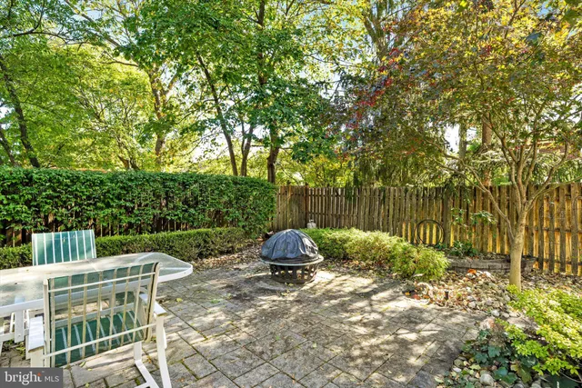 a view of backyard with table and chairs and a large tree