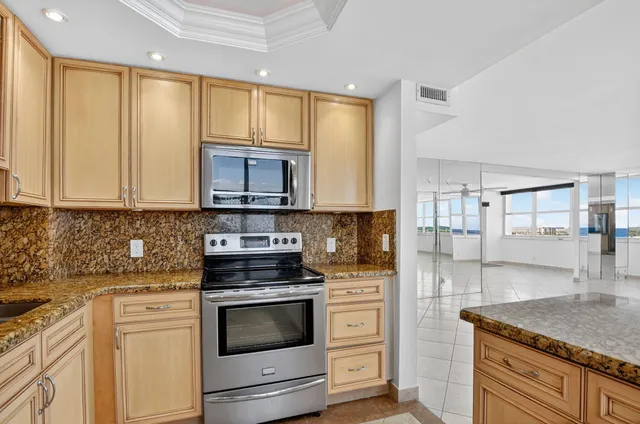 a kitchen with stainless steel appliances granite countertop a refrigerator and a stove top oven