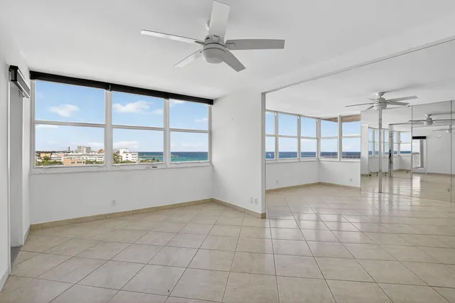 a view of empty room with wooden floor and a ceiling fan