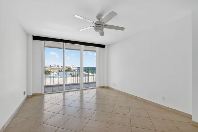 an empty room with a ceiling fan and a window