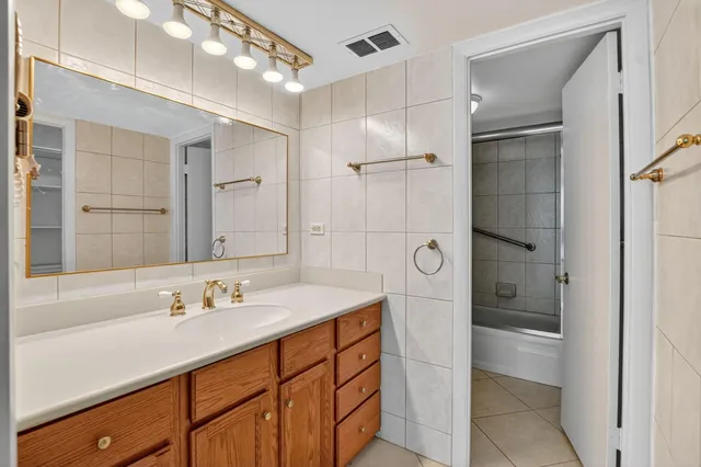 a spacious bathroom with a shower a sink and mirror