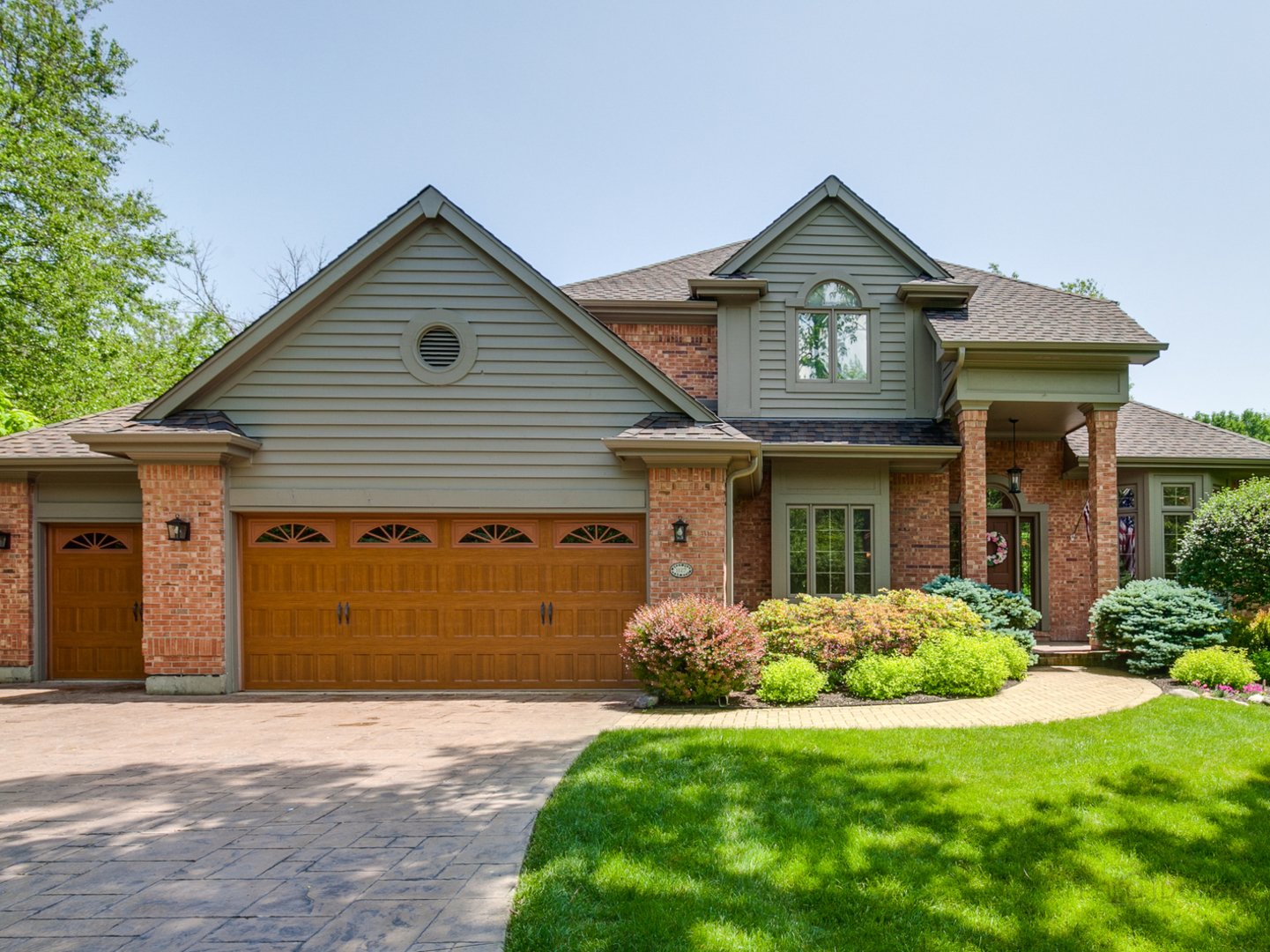 1127 South Ridge Road Lake Forest, IL 60045 - Photo 2 of 35 a front view of a house with a garden and plants