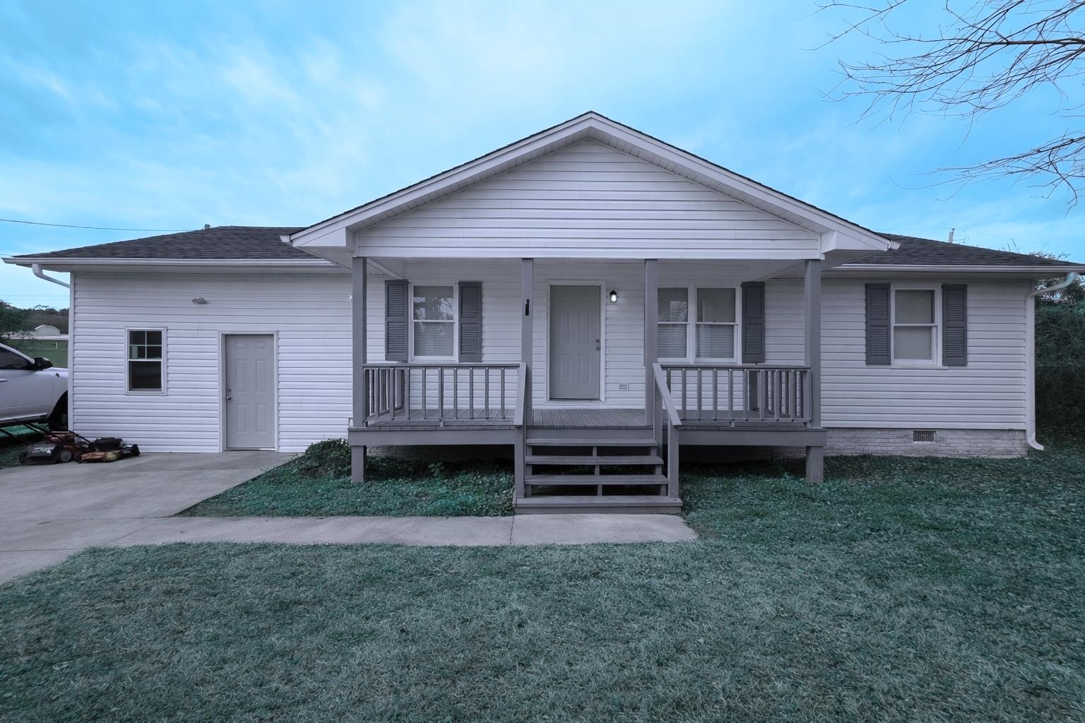 View of front of property with a porch, a front lawn, and a shingled roof