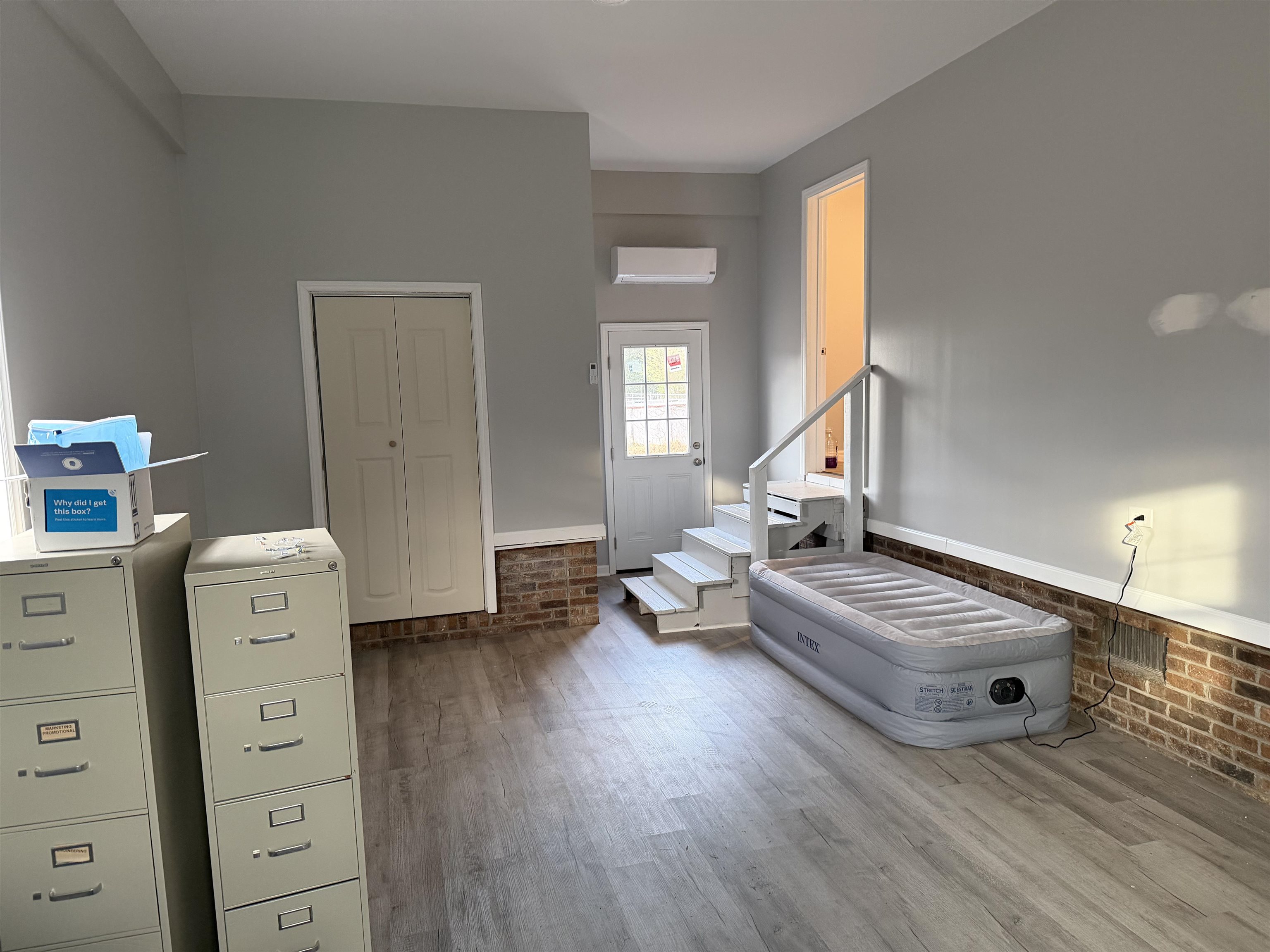 607 Geddings Drive Myrtle Beach, SC 29588 - Photo 20 of 21 Interior space featuring brick wall, light wood-style floors, stairs, a wall mounted AC, and a wainscoted wall