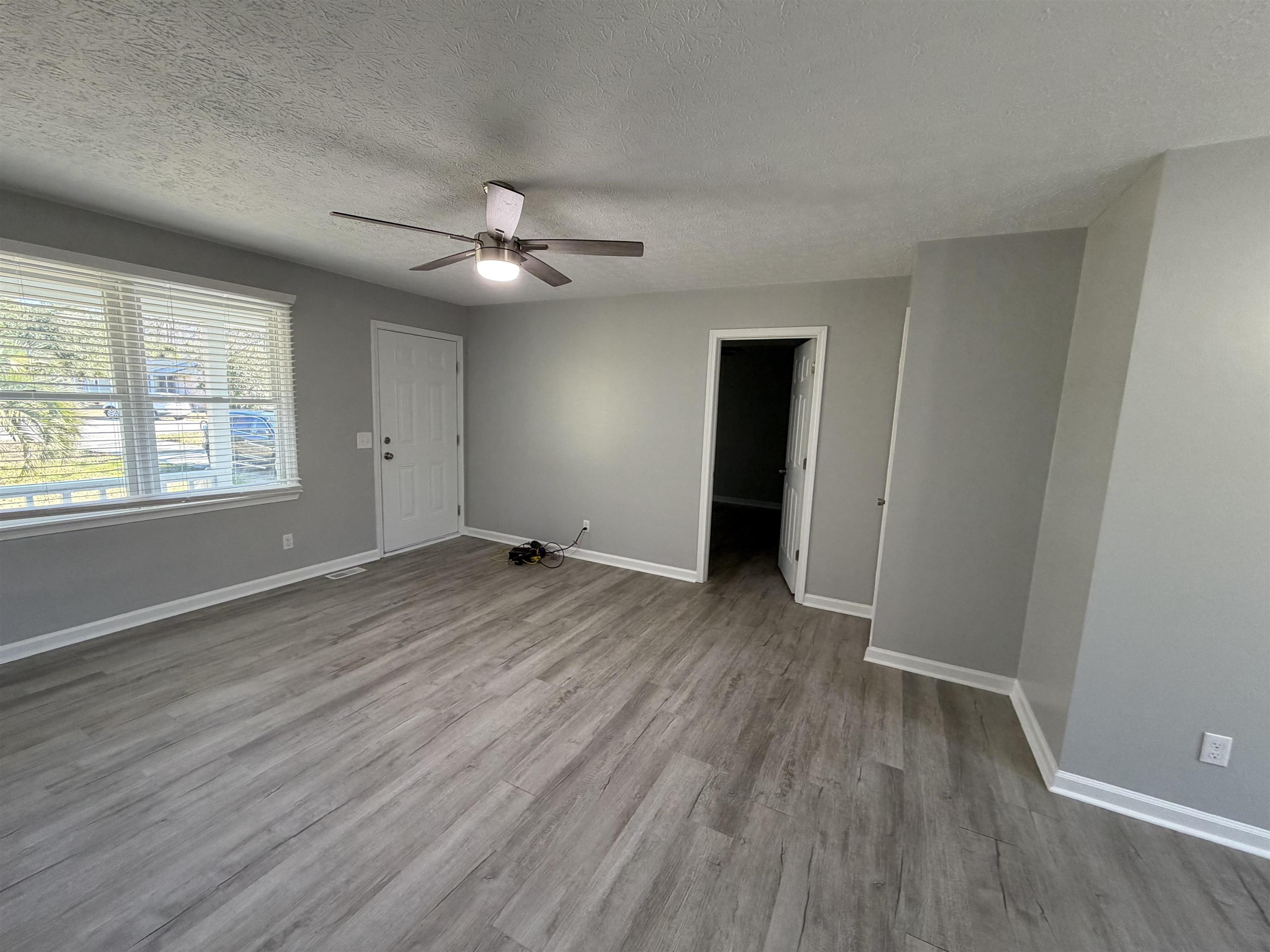 607 Geddings Drive Myrtle Beach, SC 29588 - Photo 2 of 21 Spare room with a textured ceiling, light wood-type flooring, and a ceiling fan
