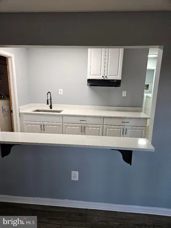 a view of a kitchen with microwave and window