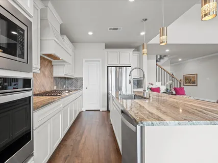 a kitchen with granite countertop a sink stove and cabinets
