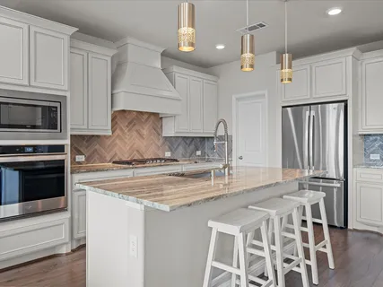 a kitchen with stainless steel appliances granite countertop a sink refrigerator and microwave