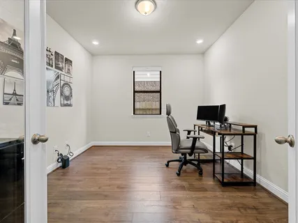 a view of a workspace with furniture and a window
