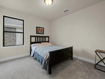 a spacious bedroom with a bed and a window