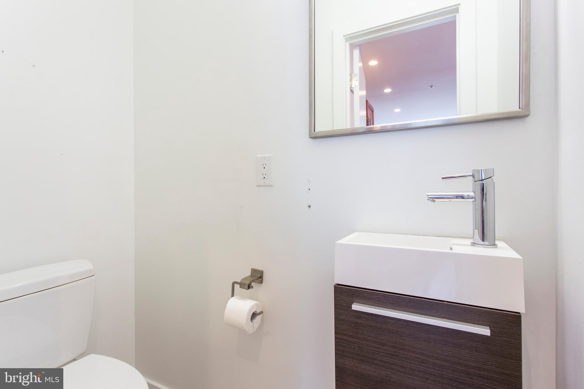 1519 Ogden Street, Unit 1 Philadelphia, PA 19130 - Photo 12 of 19 a bathroom with a sink a toilet and mirror