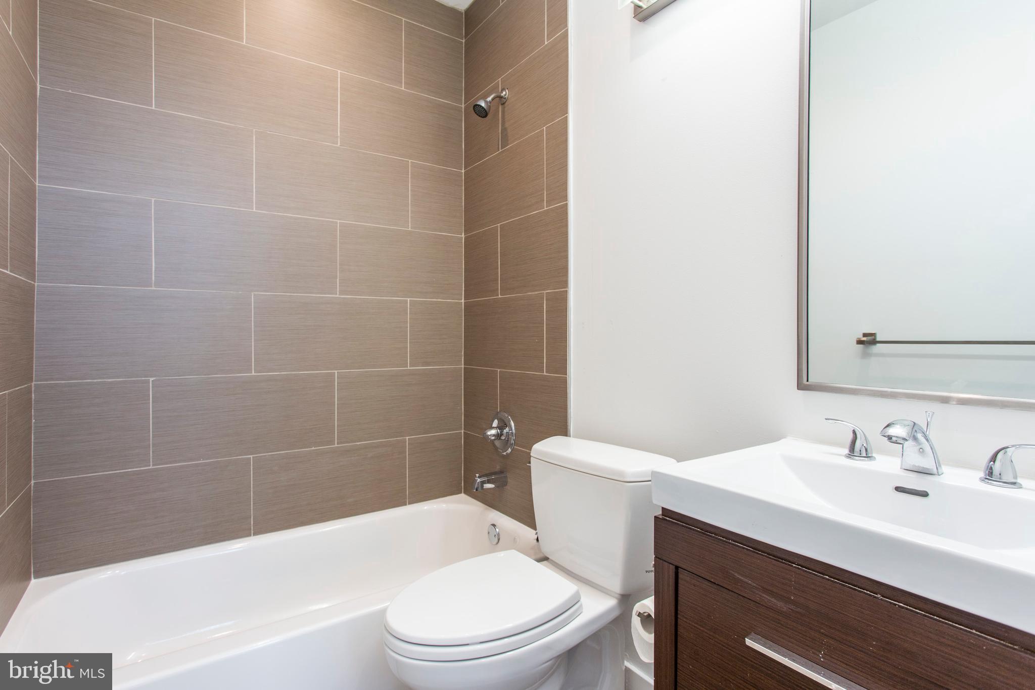 1519 Ogden Street, Unit 1 Philadelphia, PA 19130 - Photo 15 of 19 a bathroom with a sink a toilet and shower