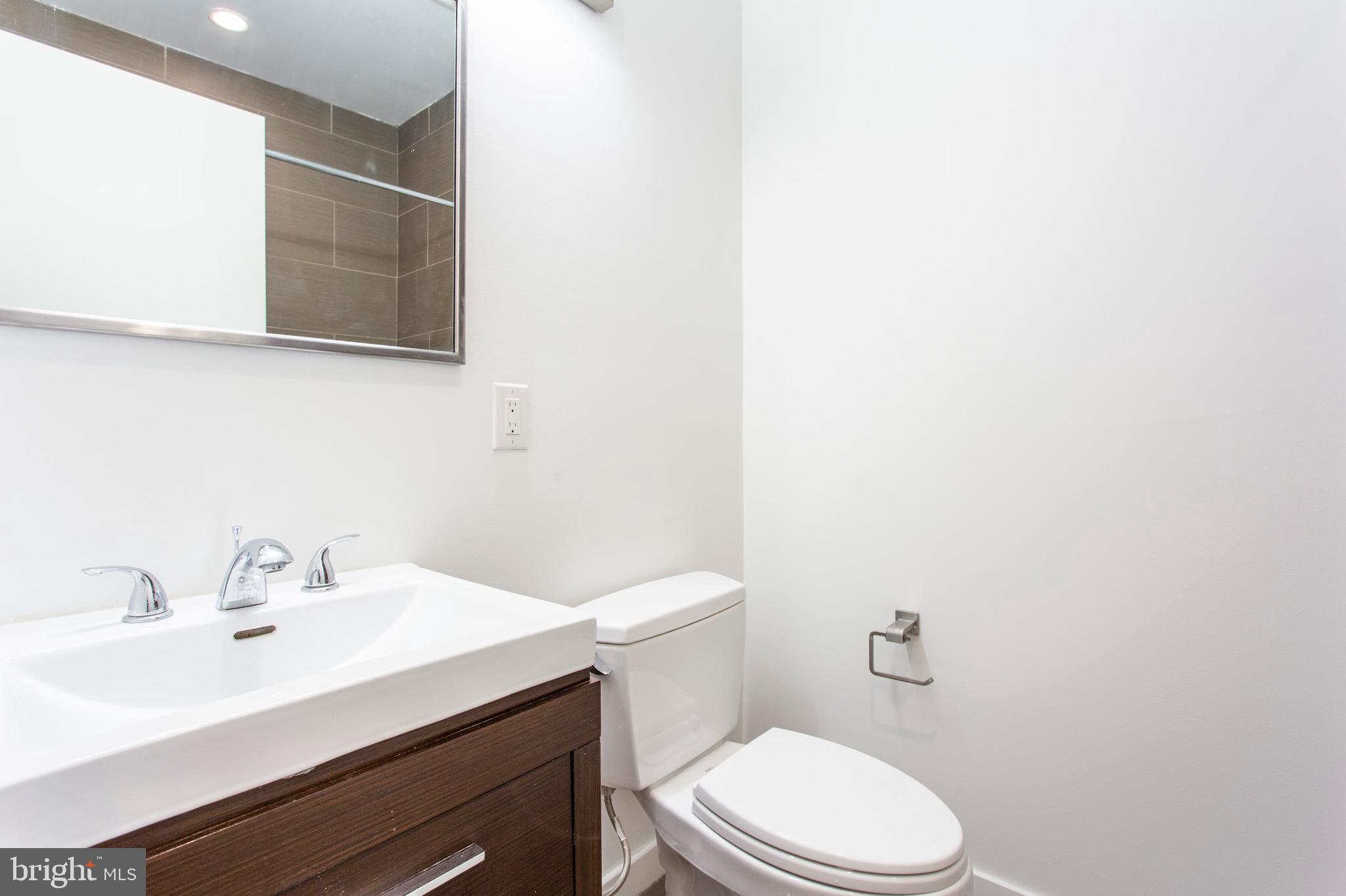 1519 Ogden Street, Unit 1 Philadelphia, PA 19130 - Photo 17 of 19 a bathroom with a sink a toilet and mirror