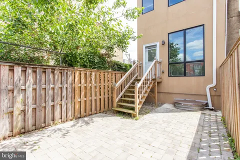 a view of kitchen with kitchen island a refrigerator a stove top oven and a sink with wooden floor