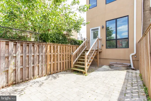 a view of kitchen with kitchen island a refrigerator a stove top oven and a sink with wooden floor