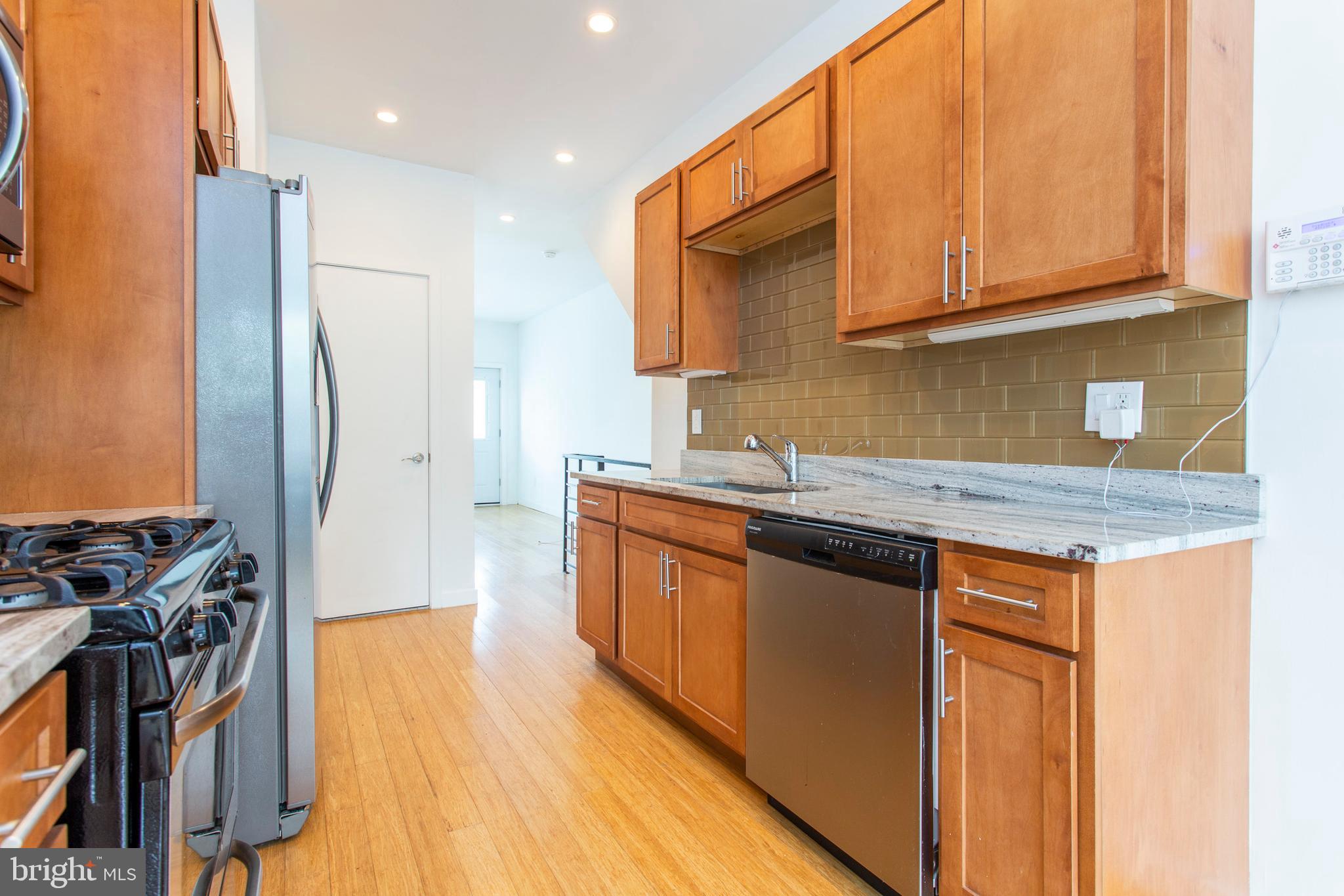 1519 Ogden Street, Unit 1 Philadelphia, PA 19130 - Photo 8 of 19 a kitchen with stainless steel appliances granite countertop a sink stove and refrigerator